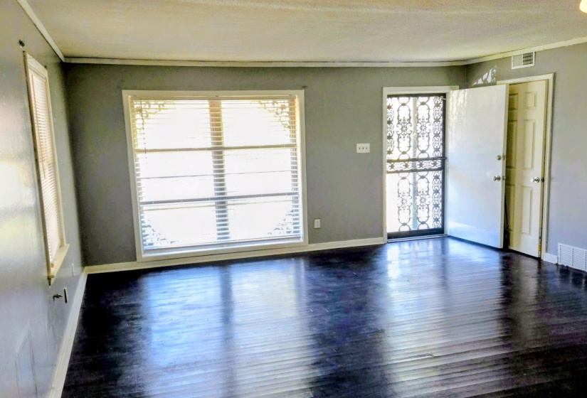 Unfurnished room featuring dark wood-style floors and ornamental molding