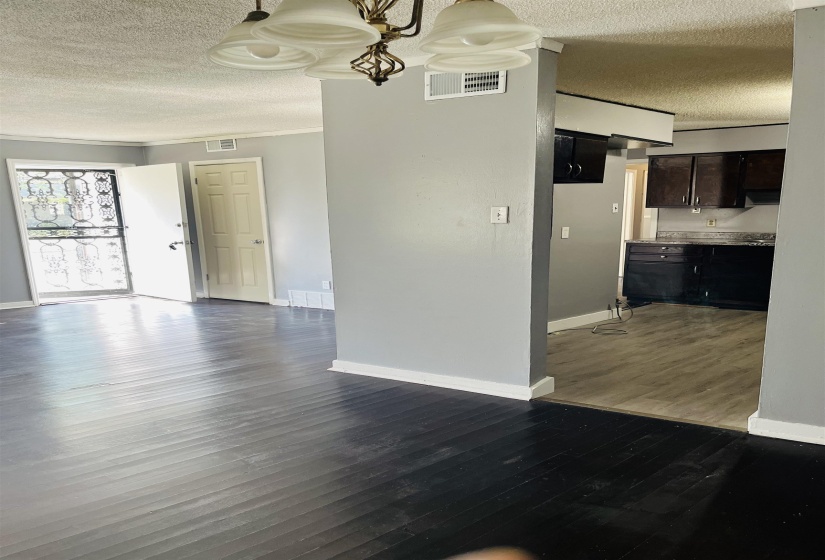 Unfurnished dining area featuring a textured ceiling and dark wood finished floors