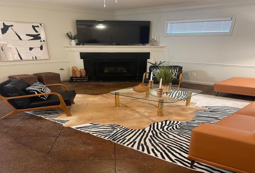 Great room featuring a fireplace, crown molding, and tile patterned flooring