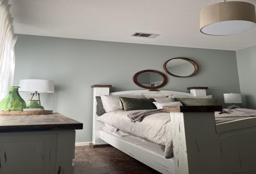 Bedroom featuring a textured ceiling and dark tile patterned flooring