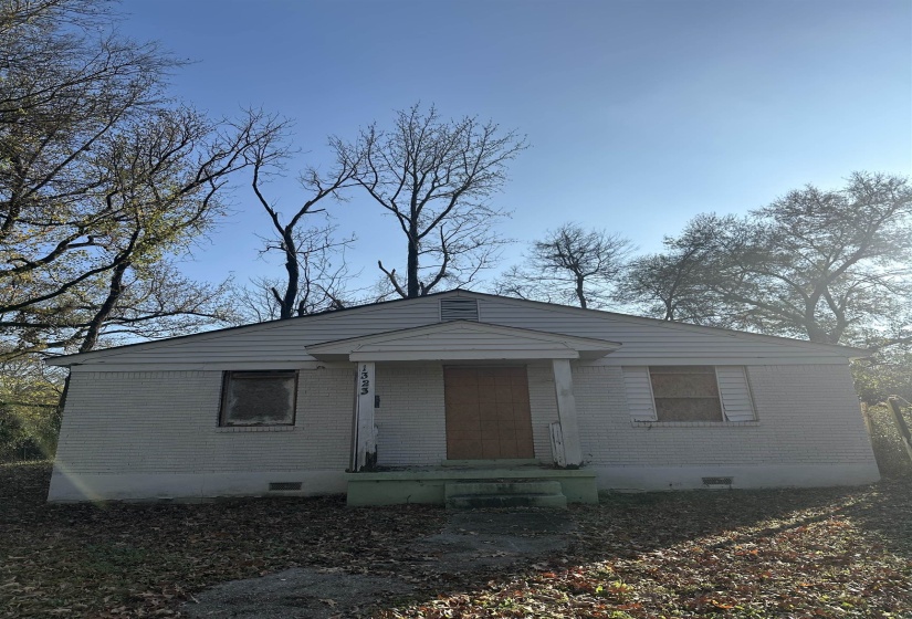 View of front of property with crawl space and brick siding