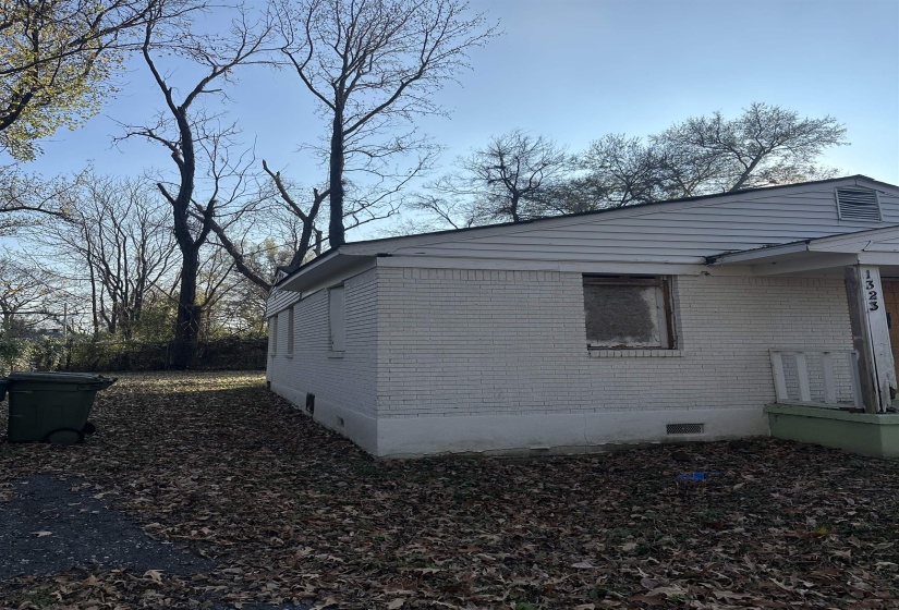 View of side of property with crawl space and brick siding