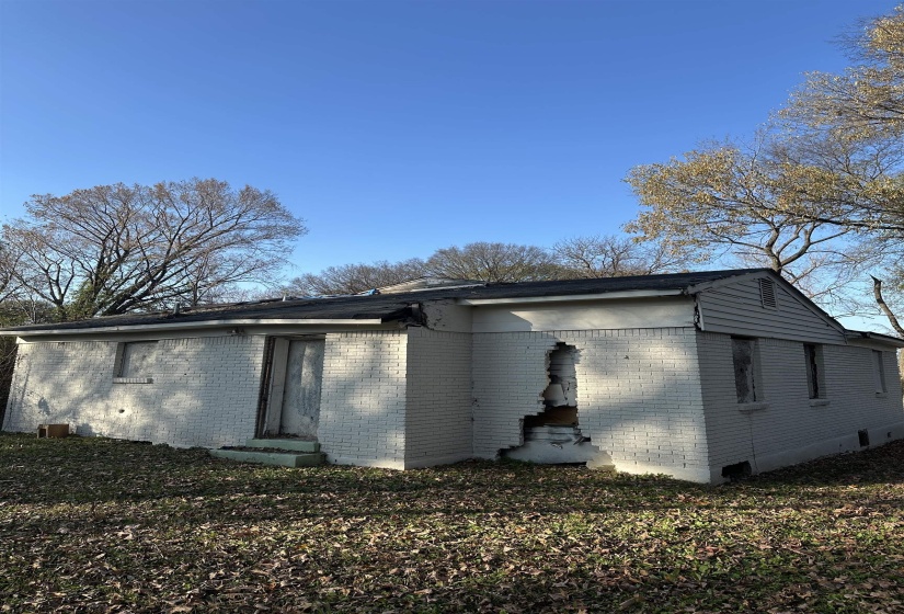 View of property exterior with brick siding, entry steps, and crawl space