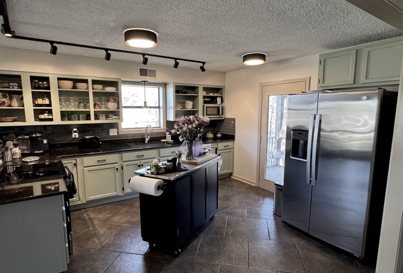 with new granite countertops, stainless steel sink and tile backsplash