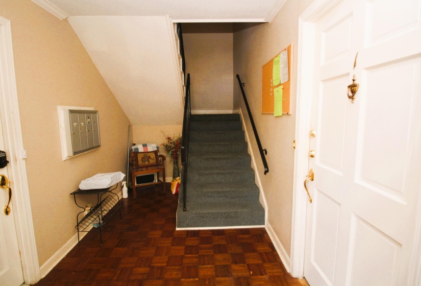 Stairway featuring mail area and crown molding
