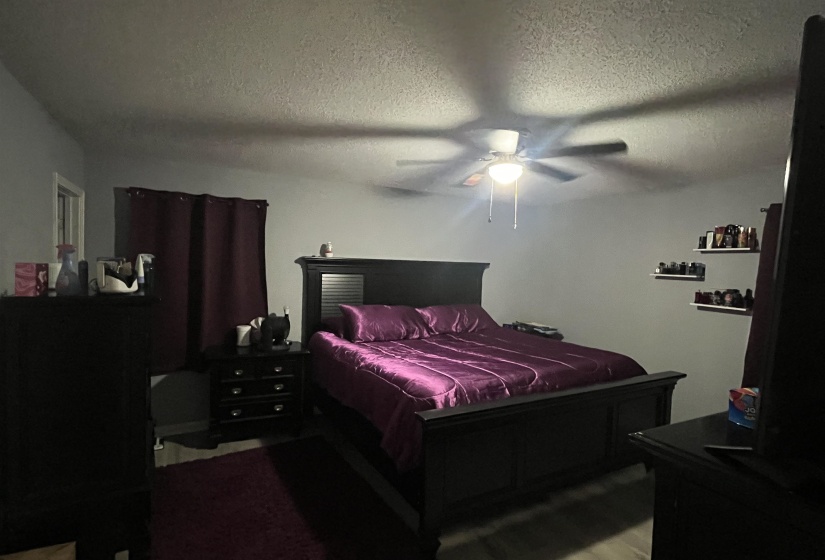 Bedroom with a textured ceiling and ceiling fan