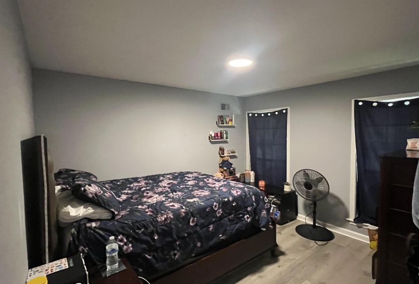 Bedroom with wood finished floors and baseboards