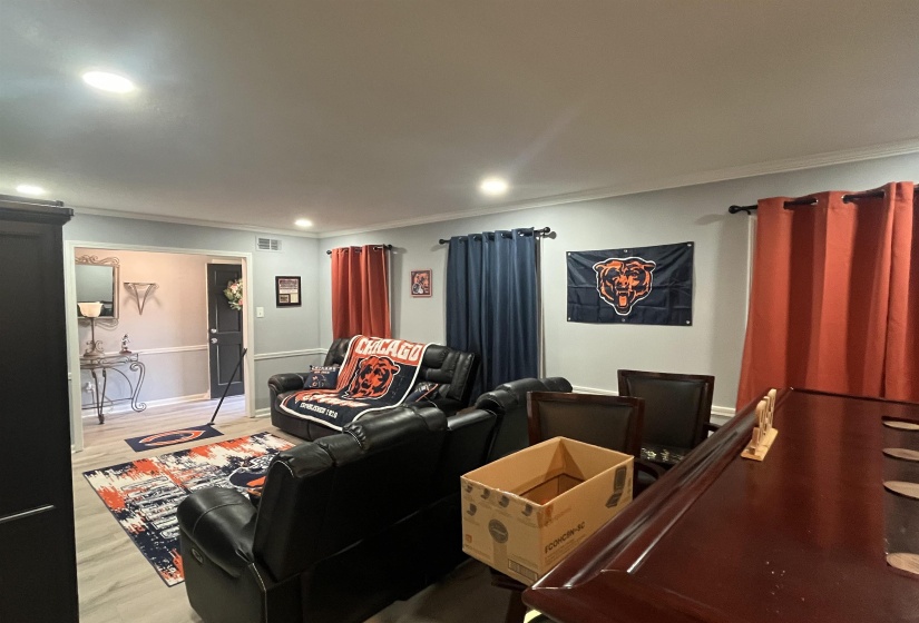 Cinema room featuring wood finished floors, crown molding, and recessed lighting