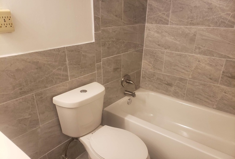 Bathroom with tile walls and shower / bathtub combination