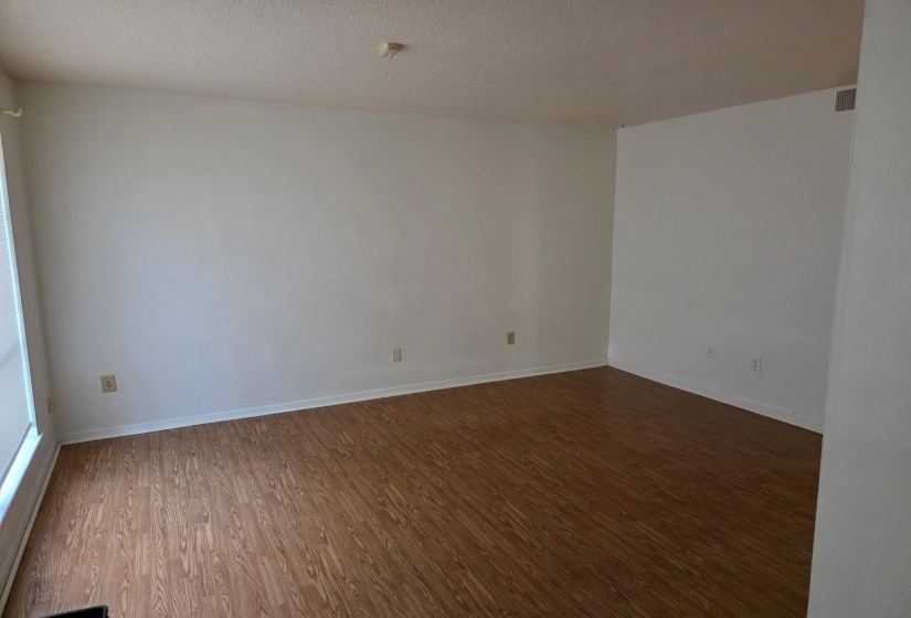 Empty room with dark wood-style flooring and a textured ceiling