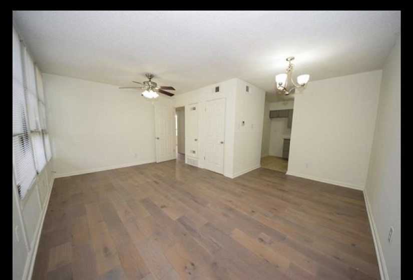Unfurnished living room featuring a chandelier and wood finished floors