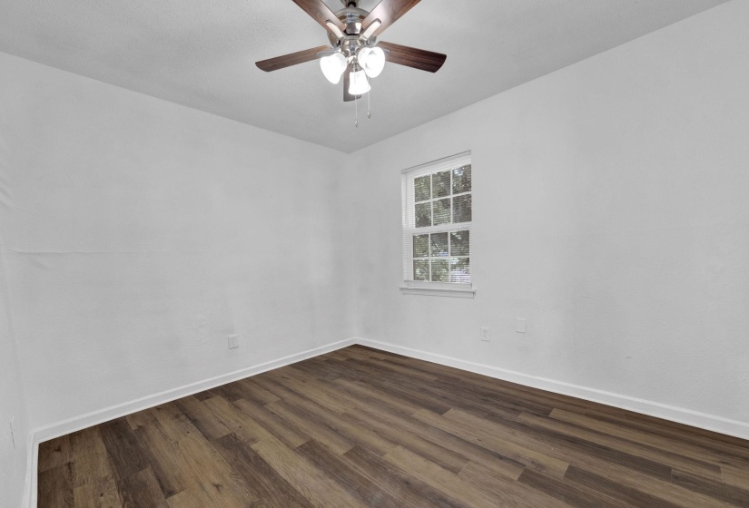 Spare room featuring dark wood finished floors and ceiling fan