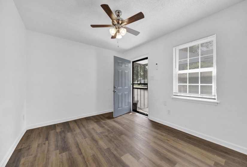 Spare room with a textured ceiling, dark wood-style flooring, and a ceiling fan