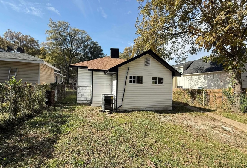 Back of house with a fenced backyard and a chimney