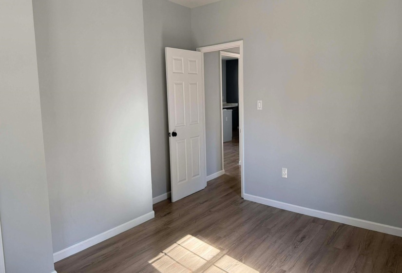 Unfurnished room with wood finished floors and baseboards