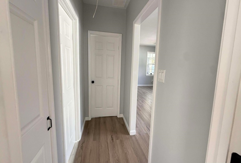 Hallway with attic access and dark wood finished floors