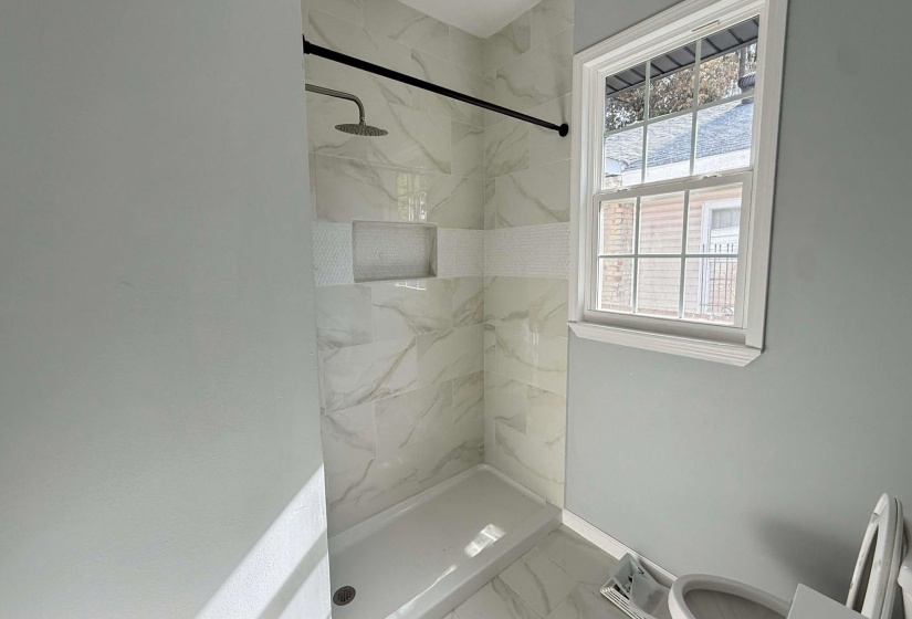 Full bath featuring a marble finish shower and marble finish flooring