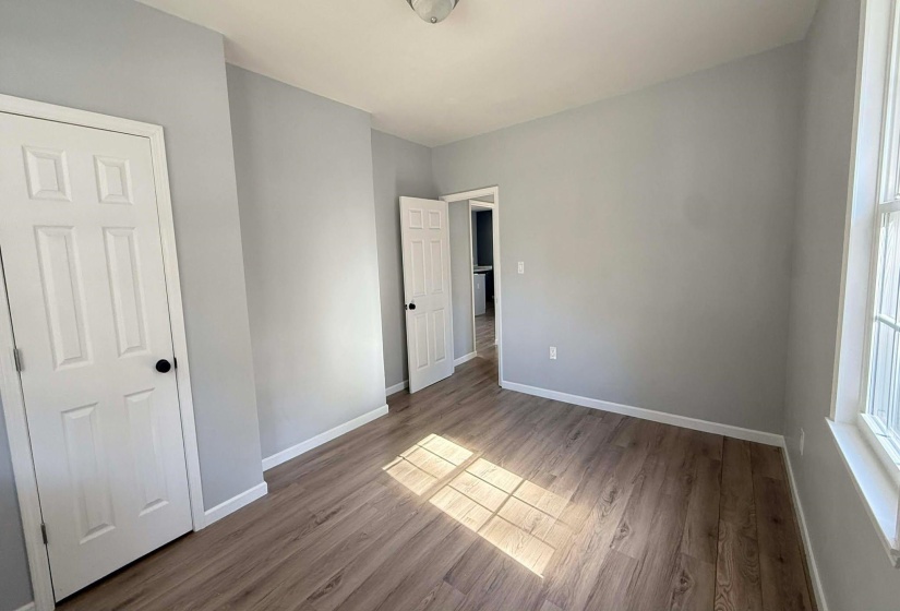 Unfurnished bedroom with baseboards and wood finished floors