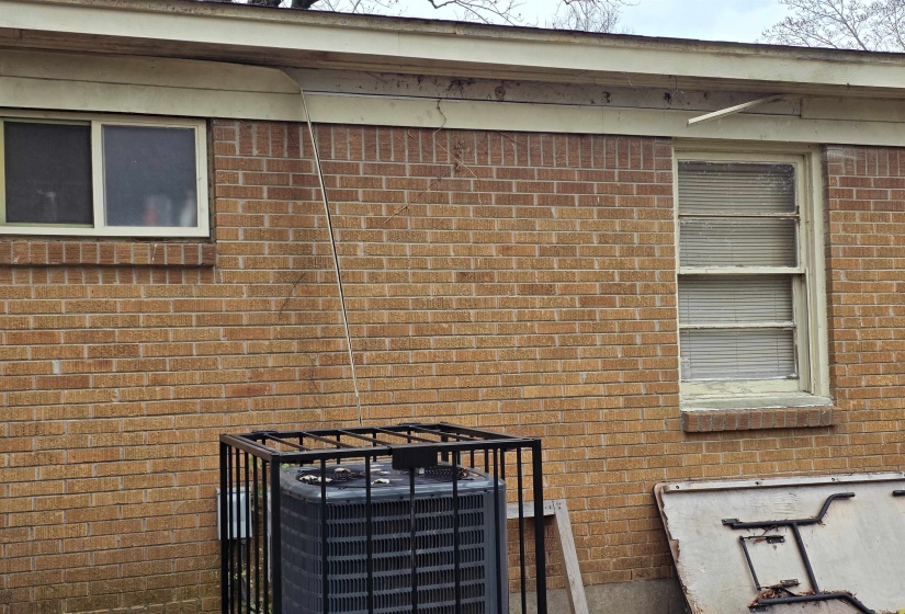 Exterior view of brick siding and a central air condition unit