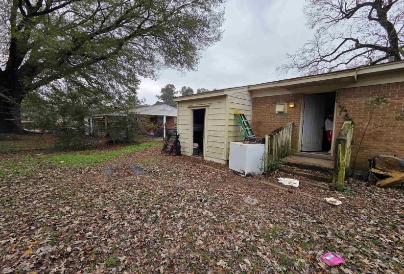 Back of property with brick siding and washer / clothes dryer