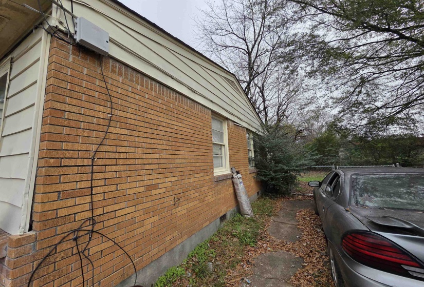 View of home's exterior with brick siding and crawl space