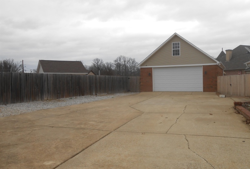 View of home's exterior featuring a Workshop, concrete driveway, and brick siding