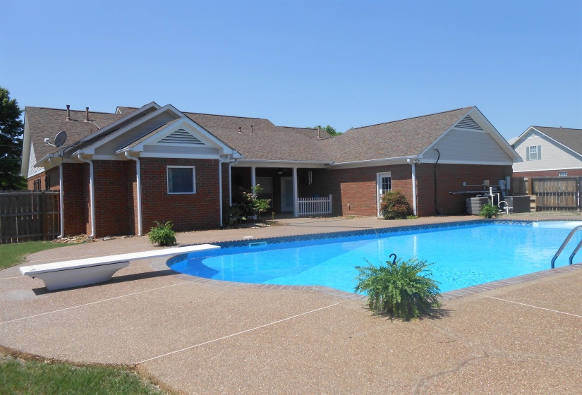 View of swimming pool featuring patio surround and a diving board