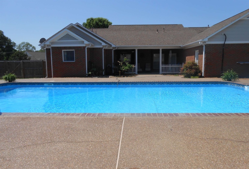 Outdoor pool with a patio area and a sunroom