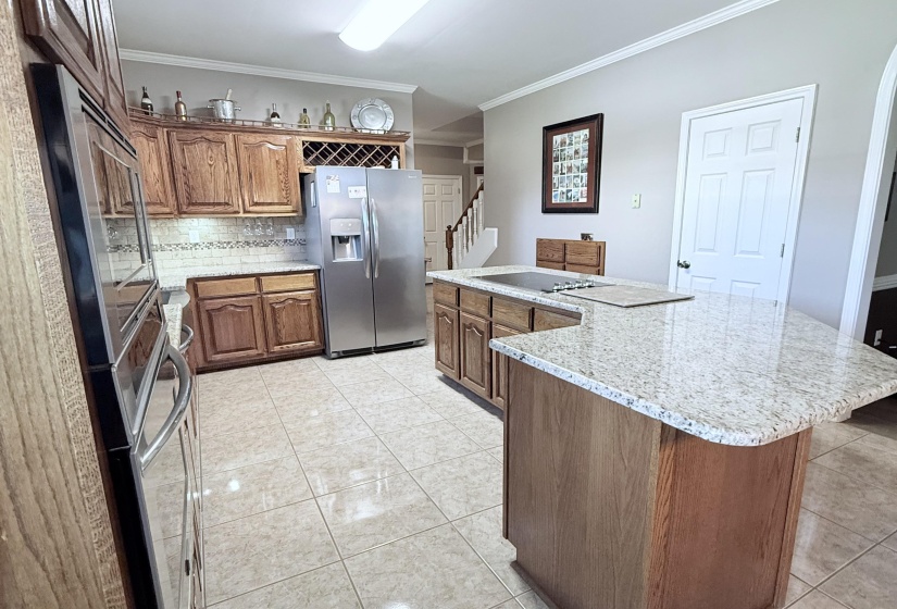 Beautiful herry cabinets with granite countertops stainless steel appliances and tile floor.