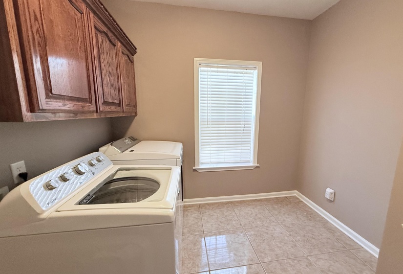Laundry room is bright and neutral with ample storage.
