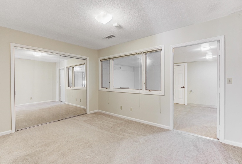 Unfurnished bedroom with light colored carpet, a textured ceiling, and a closet