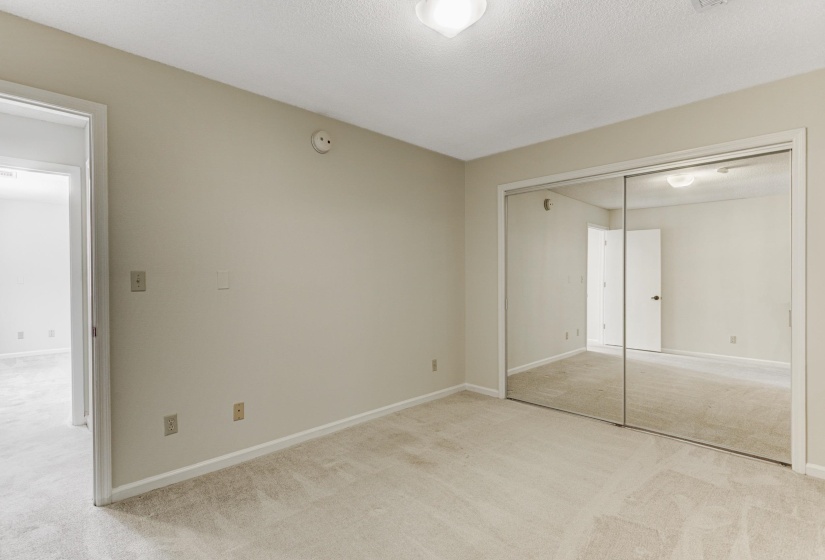Unfurnished bedroom with light carpet, a closet, and a textured ceiling