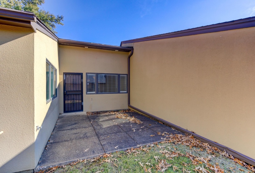 Entrance to property with stucco siding and a patio area