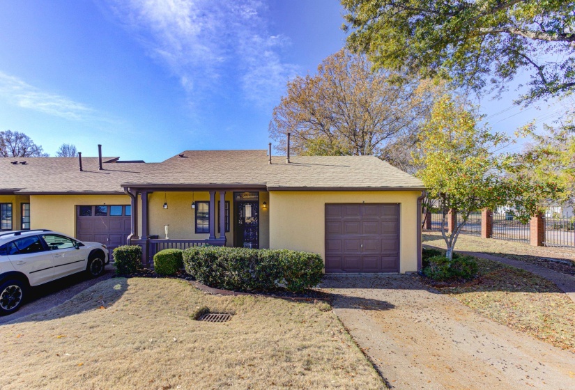 Ranch-style home featuring covered porch, stucco siding, a shingled roof, and a garage