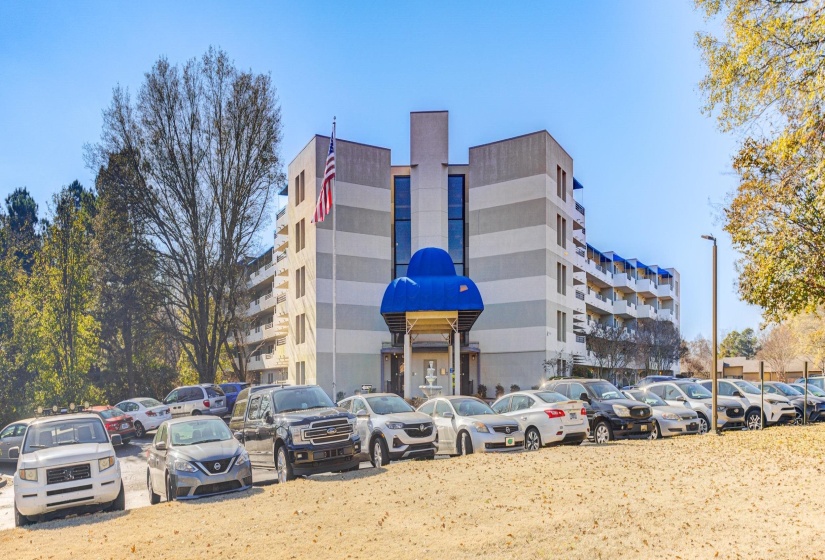 View of apartment building / complex with uncovered parking