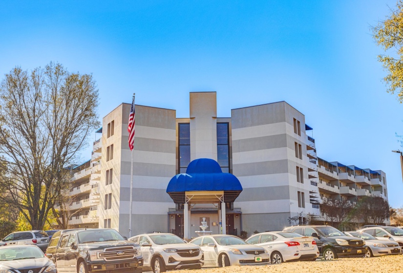 View of apartment building / complex featuring uncovered parking