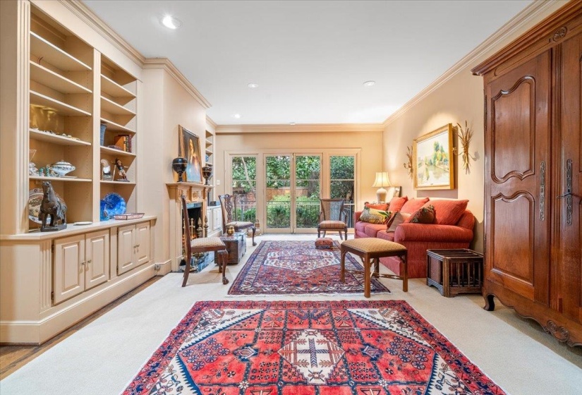 Living room featuring ornamental molding, a fireplace, light carpet, and recessed lighting