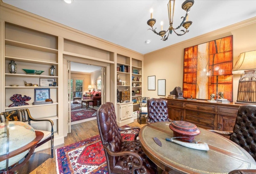 Office featuring ornamental molding, light wood-style floors, a chandelier, and built in features