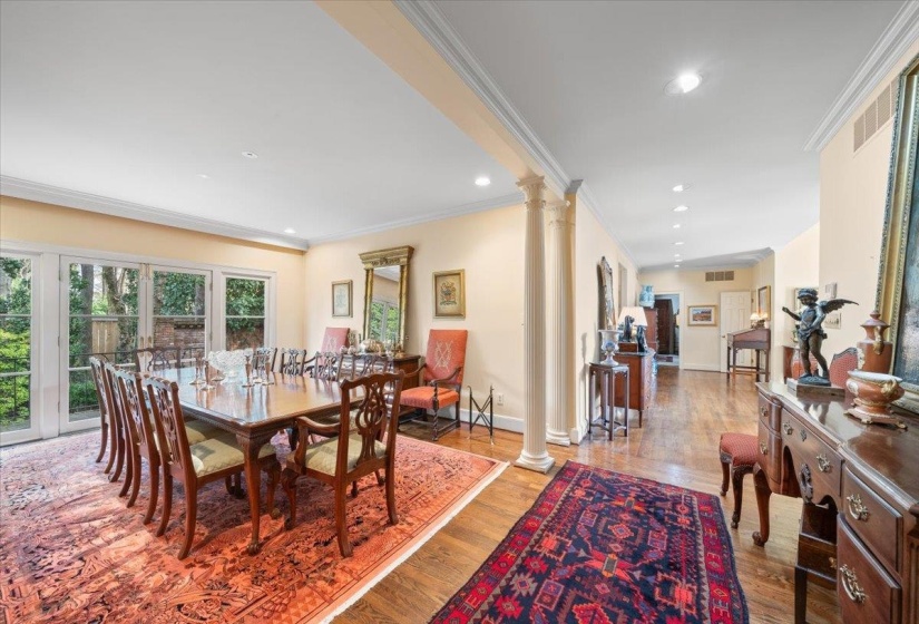 Dining space featuring ornate columns, crown molding, light wood finished floors, and recessed lighting