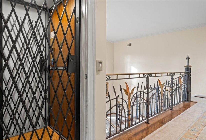Corridor with elevator, crown molding, wood finished floors, and an upstairs landing