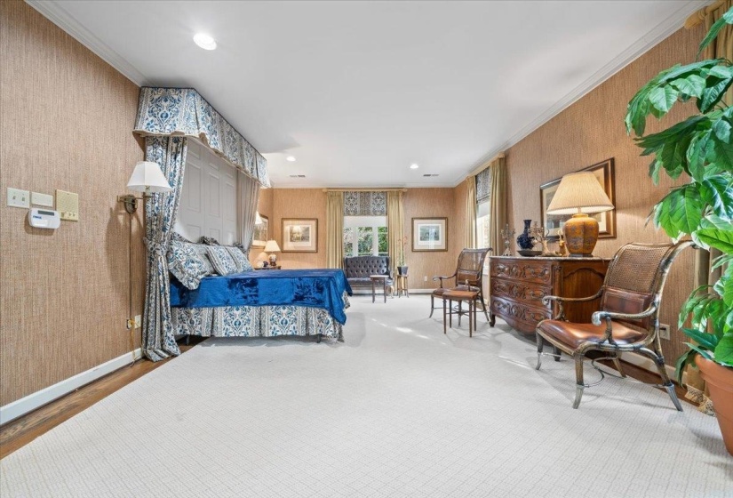 Bedroom featuring wallpapered walls, crown molding, and recessed lighting