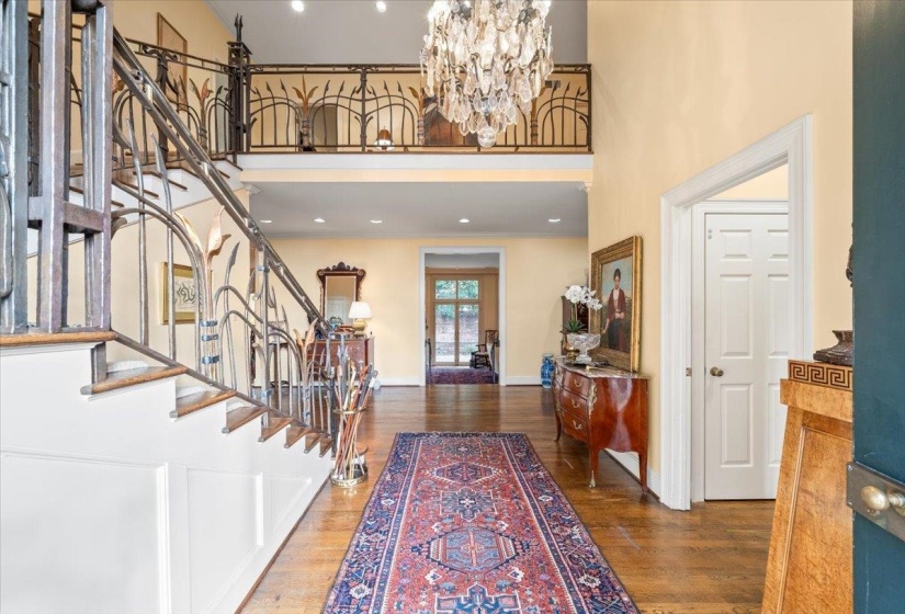 Foyer entrance with stairway, dark wood-style floors, a chandelier, a towering ceiling, and recessed lighting