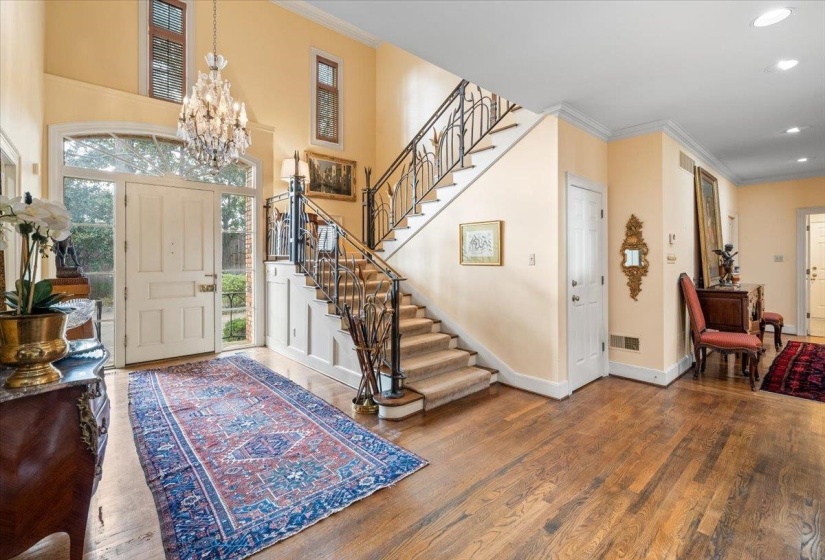 Entryway with ornamental molding, wood finished floors, a chandelier, stairs, and recessed lighting