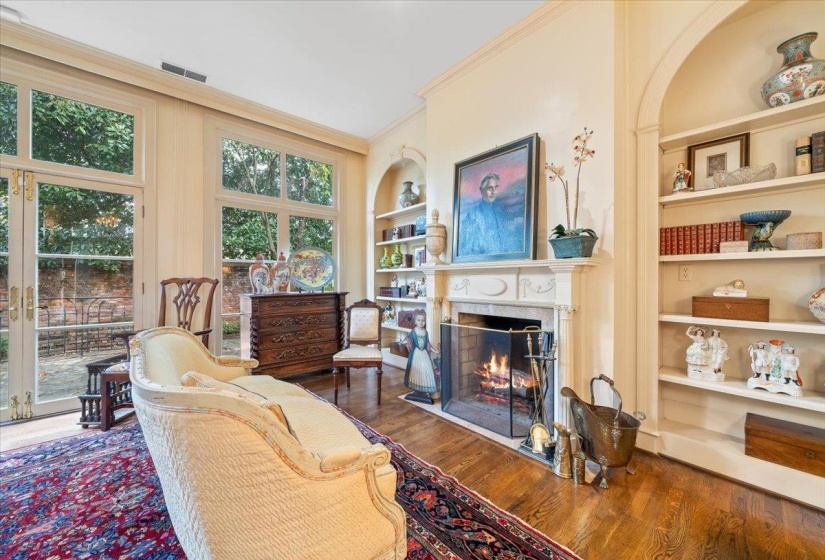Living area featuring built in features, ornamental molding, wood finished floors, and a premium fireplace