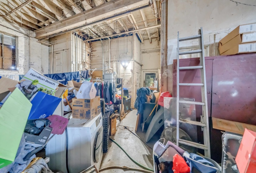 Miscellaneous room with washer / dryer and unfinished concrete flooring