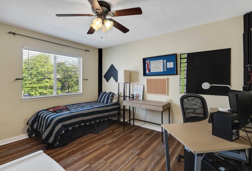 Bedroom featuring an office area, dark wood finished floors, a textured ceiling, and ceiling fan