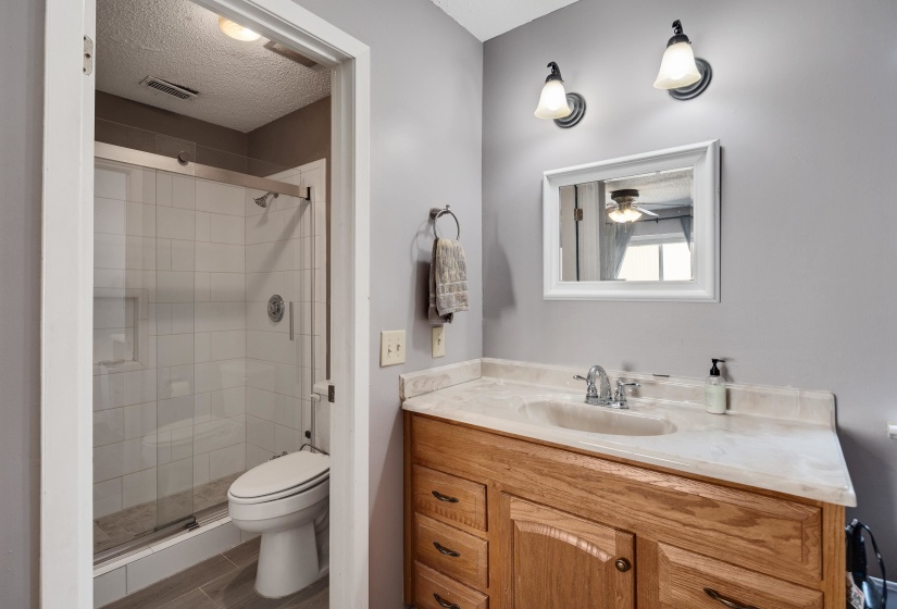 Bathroom featuring vanity, a shower stall, and a textured ceiling