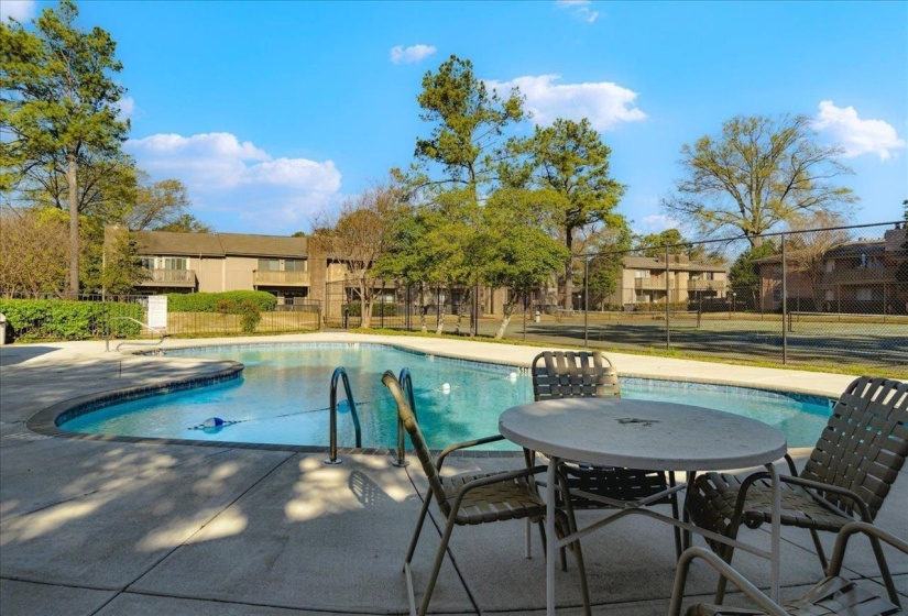 Community pool with a patio area and a residential view