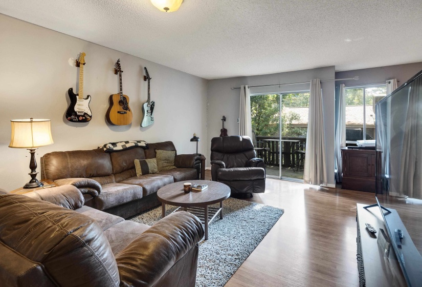 Living room with a textured ceiling and wood finished floors