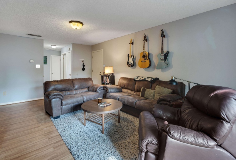 Living area featuring light wood finished floors and a textured ceiling